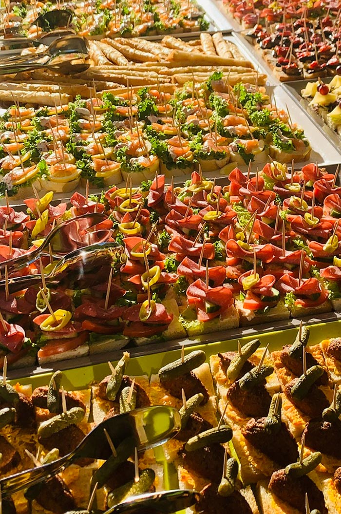 Ein reichhaltiges Buffet mit bunten Häppchen, frischen Kräutern und Spießen